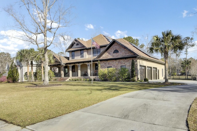 view of front of home with a porch, stucco siding, driveway, and a front lawn