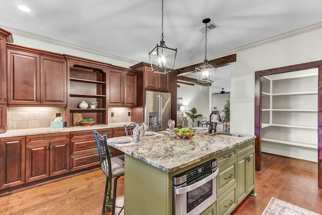 kitchen featuring crown molding, light wood-type flooring, decorative backsplash, stainless steel appliances, and a sink