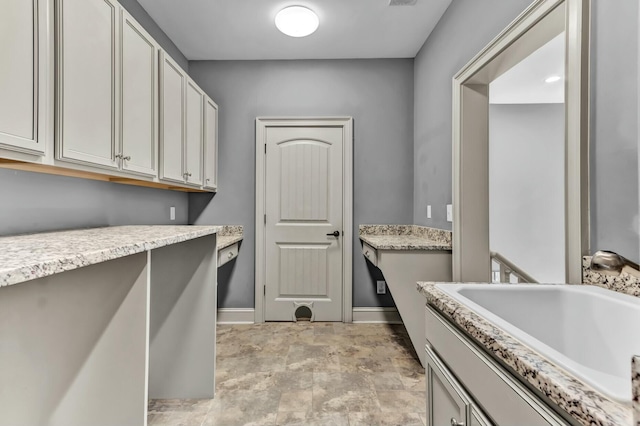 laundry room with baseboards and a sink