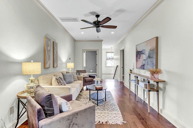 living room with a ceiling fan, baseboards, wood finished floors, visible vents, and ornamental molding