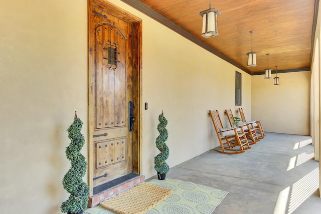 view of exterior entry featuring stucco siding and covered porch