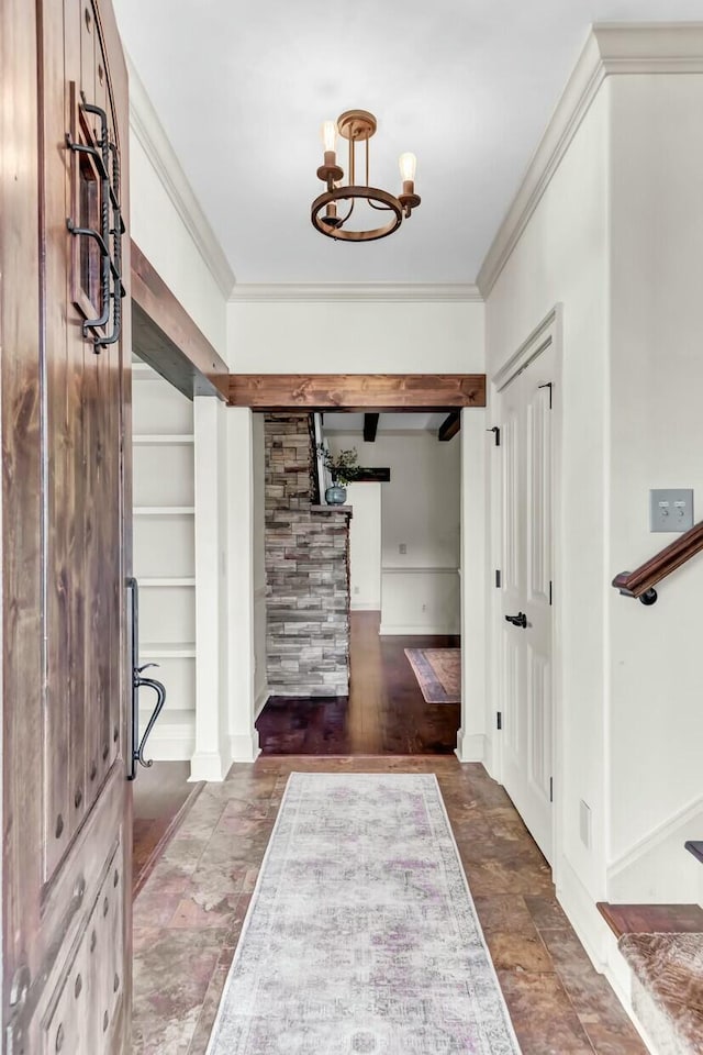 entrance foyer with a chandelier and crown molding