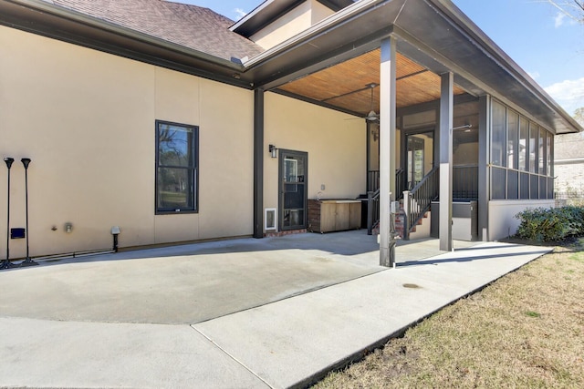 rear view of property with a sunroom and stucco siding