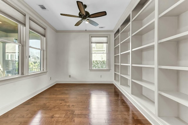 unfurnished room featuring visible vents, baseboards, and wood finished floors