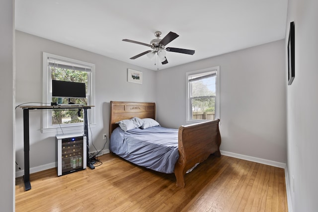 bedroom with ceiling fan, hardwood / wood-style floors, and beverage cooler