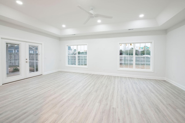 spare room featuring light hardwood / wood-style flooring, french doors, and a wealth of natural light