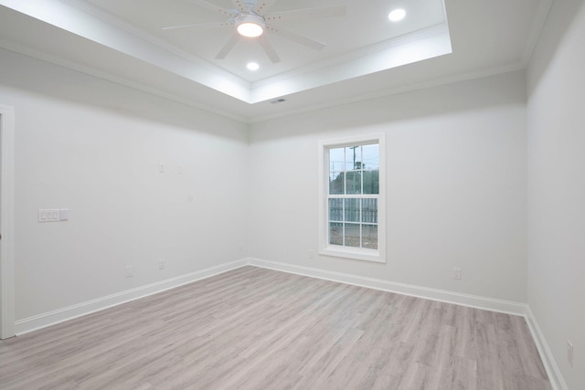 unfurnished room with ornamental molding, ceiling fan, light hardwood / wood-style floors, and a raised ceiling