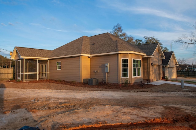 view of property exterior with a garage and a sunroom