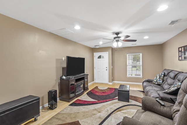 living room featuring ceiling fan and light hardwood / wood-style flooring