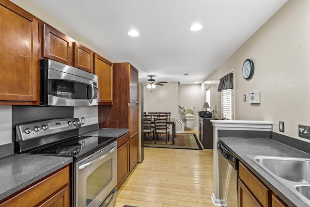 kitchen featuring stainless steel appliances, ceiling fan, and light hardwood / wood-style floors