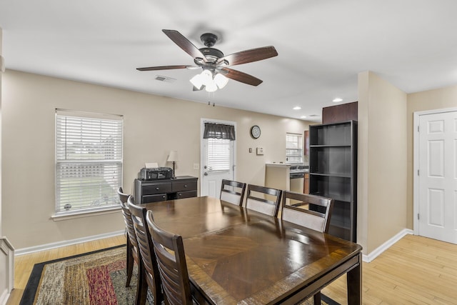 dining space featuring wine cooler, ceiling fan, light hardwood / wood-style flooring, and a healthy amount of sunlight