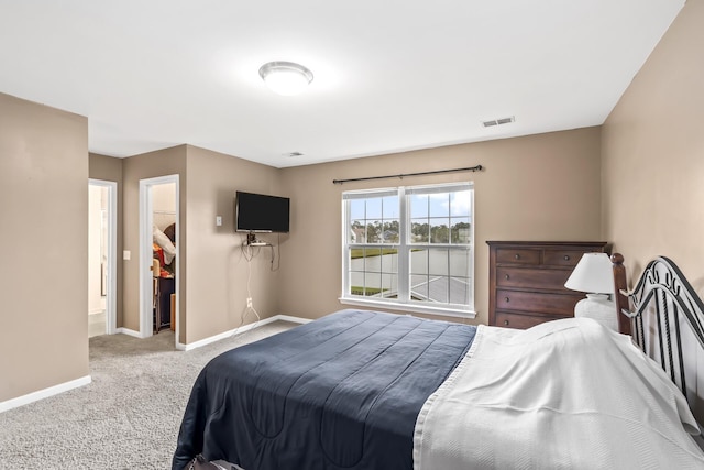 carpeted bedroom featuring a walk in closet