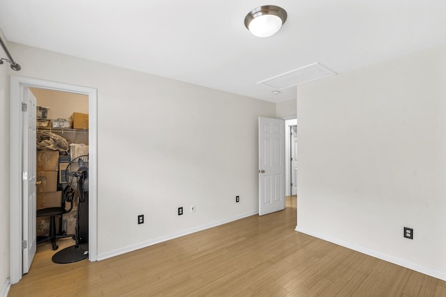 bedroom featuring a spacious closet, a closet, and light wood-type flooring