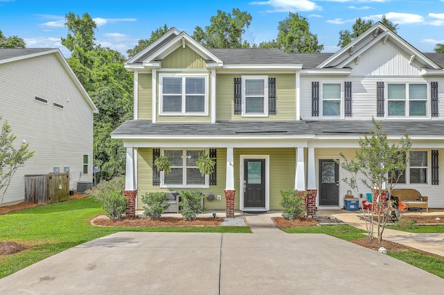 9101 Parlor Dr, Ladson, SC 29456 - view of front of house with covered porch, board and batten siding, and a front lawn