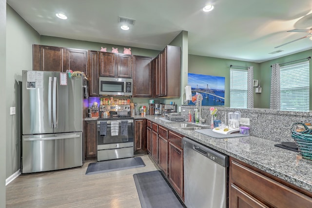 9101 Parlor Dr, Ladson, SC 29456 - kitchen featuring stainless steel appliances, light wood-style floors, light stone countertops, dark brown cabinets, and recessed lighting