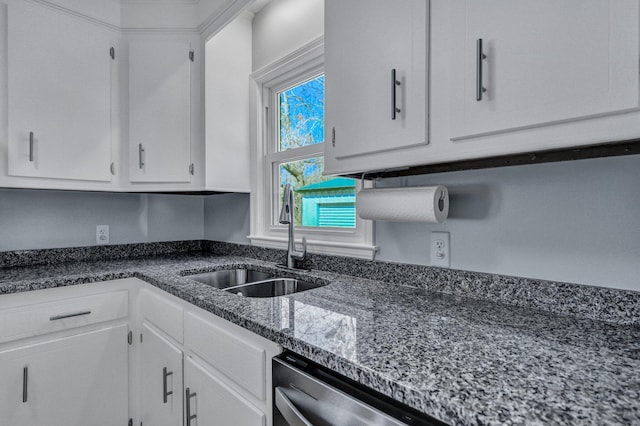 kitchen with dark stone counters, a sink, dishwasher, and white cabinets