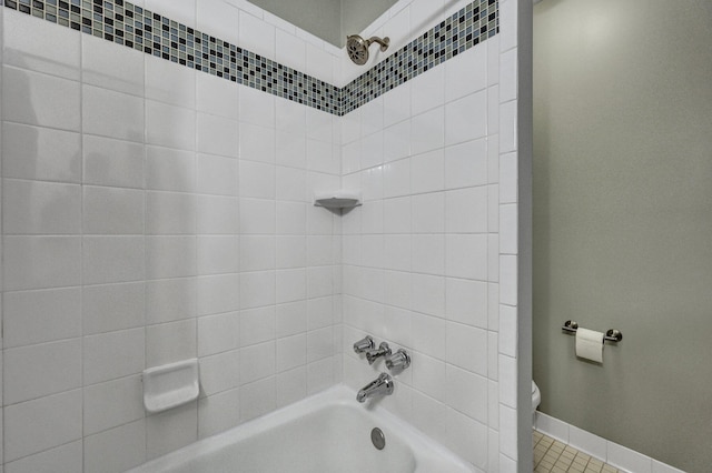 bathroom featuring baseboards, shower / bathing tub combination, and toilet