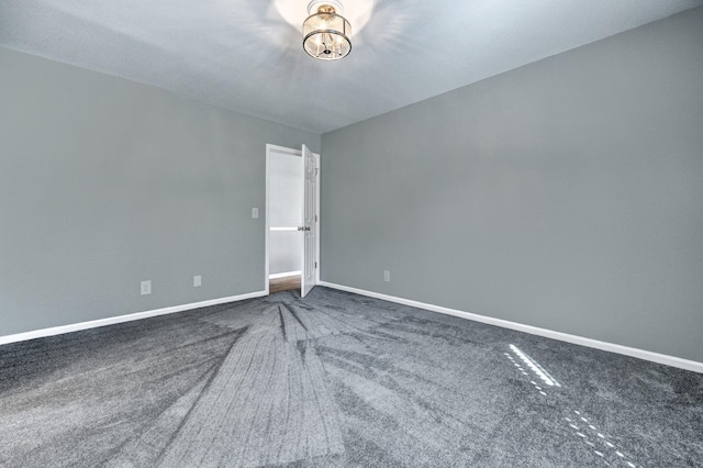 carpeted empty room featuring baseboards