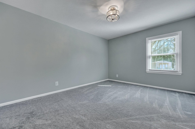 carpeted spare room featuring baseboards