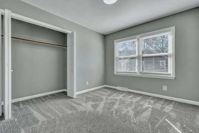 unfurnished bedroom featuring a closet, baseboards, visible vents, and carpet flooring