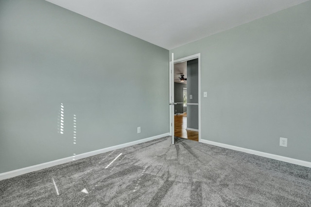 carpeted spare room featuring baseboards