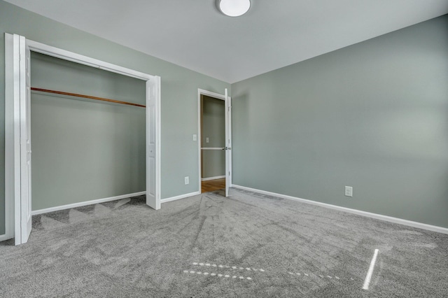 unfurnished bedroom with a closet, carpet flooring, and baseboards