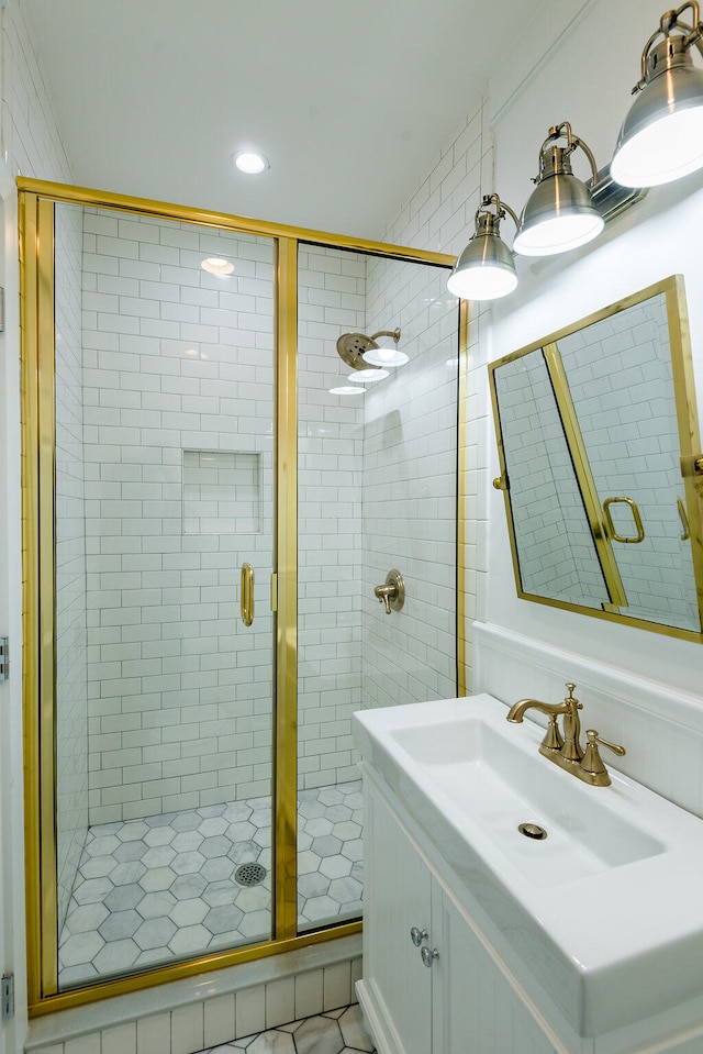 bathroom featuring a shower with door and vanity