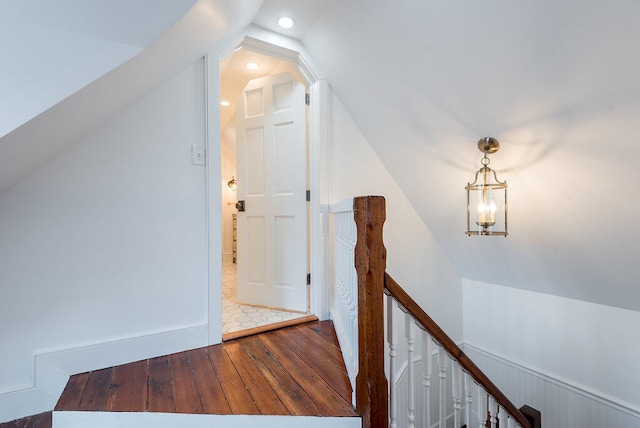 hallway featuring wood-type flooring and vaulted ceiling