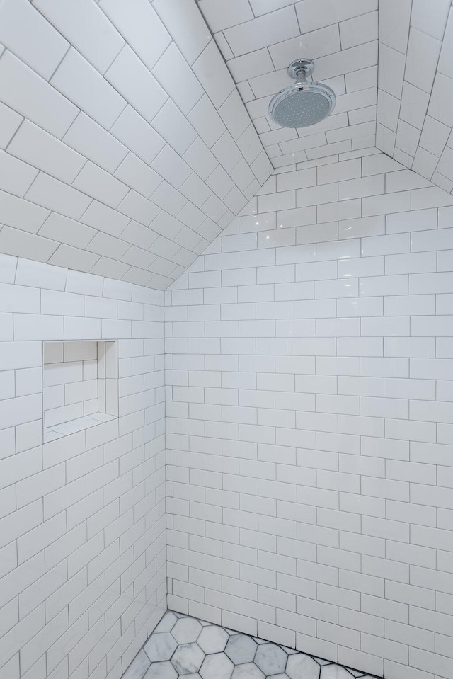 bathroom featuring a tile shower and vaulted ceiling