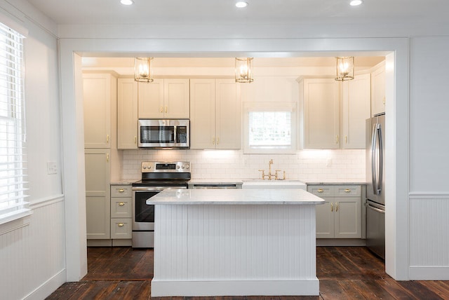 kitchen with dark wood-type flooring, pendant lighting, and stainless steel appliances