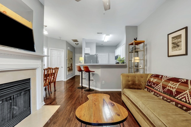 living room with dark hardwood / wood-style floors and ceiling fan