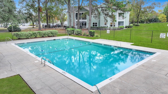 view of swimming pool with a lawn