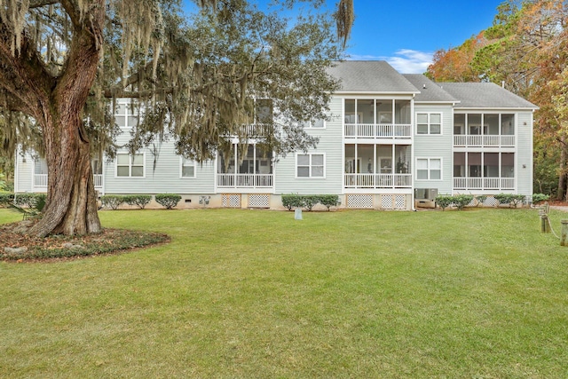 rear view of house with a sunroom, a yard, and cooling unit