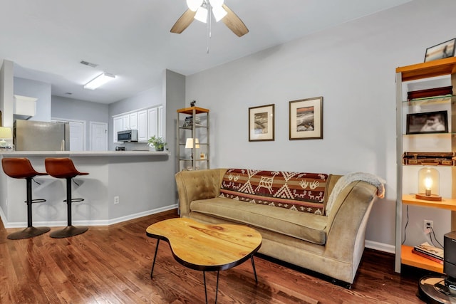 living room with ceiling fan and dark wood-type flooring