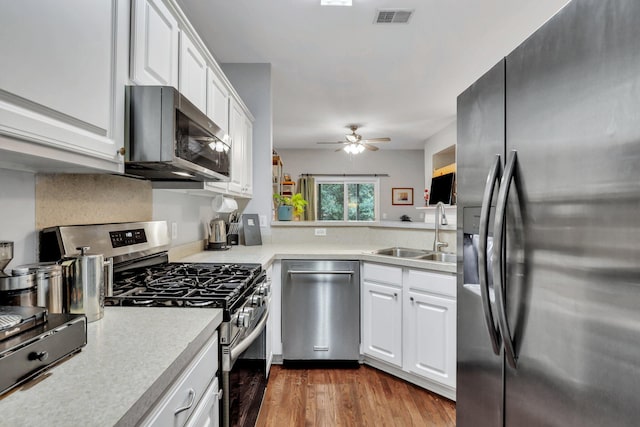 kitchen with sink, ceiling fan, dark hardwood / wood-style flooring, white cabinetry, and stainless steel appliances