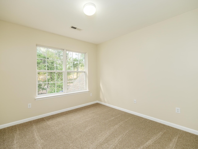 carpeted spare room with baseboards and visible vents