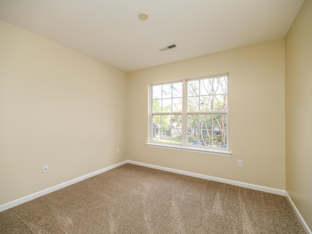 carpeted spare room with visible vents and baseboards
