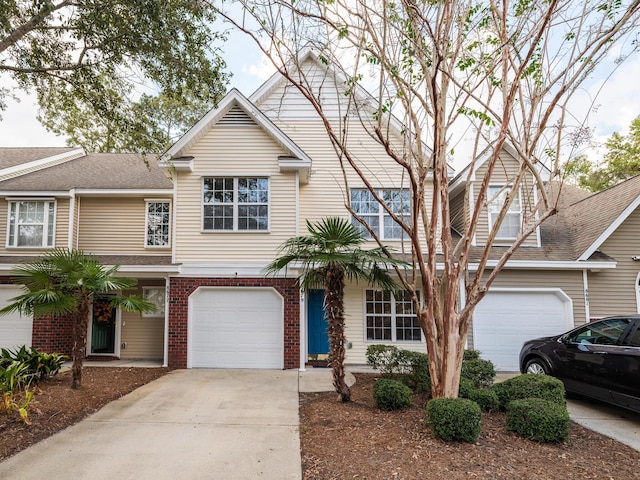 view of front of property featuring a garage, brick siding, and concrete driveway