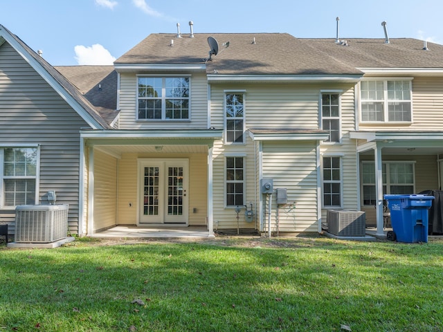 rear view of property with french doors, central AC unit, and a yard