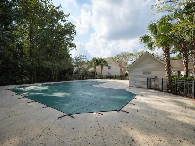 community pool with a patio and fence