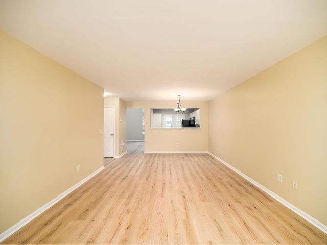interior space with a chandelier, light wood-type flooring, and baseboards