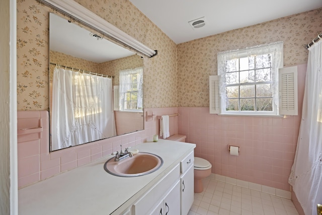 bathroom with tile patterned floors, toilet, vanity, and plenty of natural light