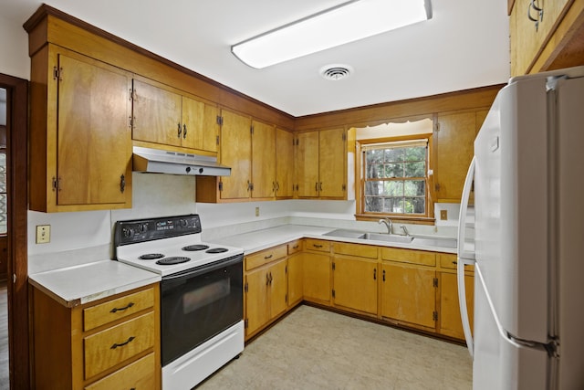 kitchen with white refrigerator, range with electric cooktop, and sink