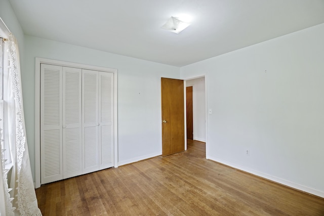 unfurnished bedroom with light hardwood / wood-style floors and a closet