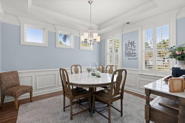 dining room featuring a tray ceiling, a wealth of natural light, hardwood / wood-style floors, and a notable chandelier