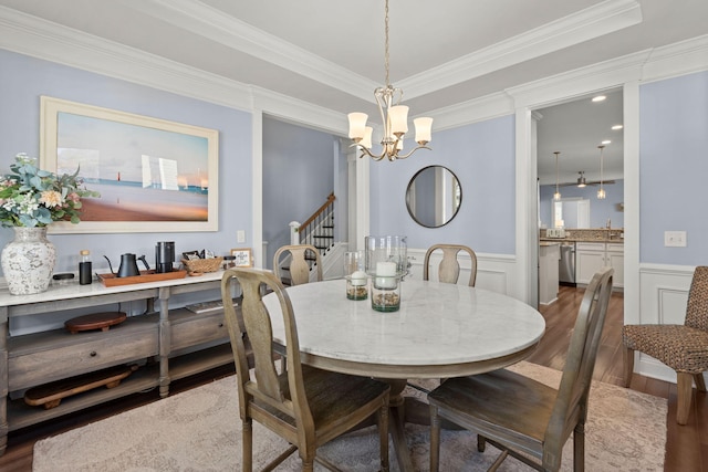 dining room with crown molding, dark hardwood / wood-style flooring, sink, and an inviting chandelier