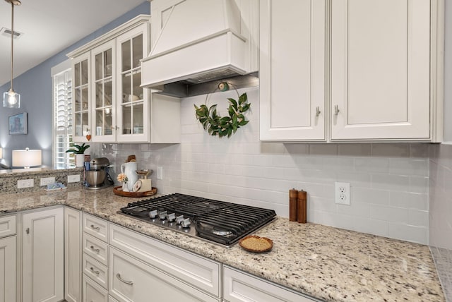 kitchen featuring white cabinets, pendant lighting, stainless steel gas stovetop, and custom exhaust hood