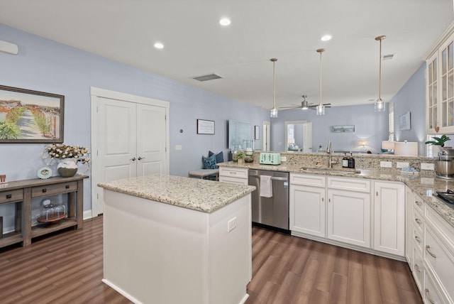 kitchen featuring white cabinets, sink, decorative light fixtures, dishwasher, and a center island