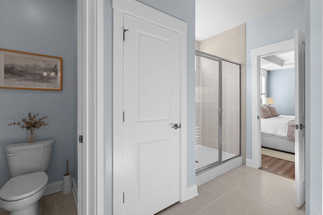 bathroom featuring tile patterned floors, toilet, and walk in shower