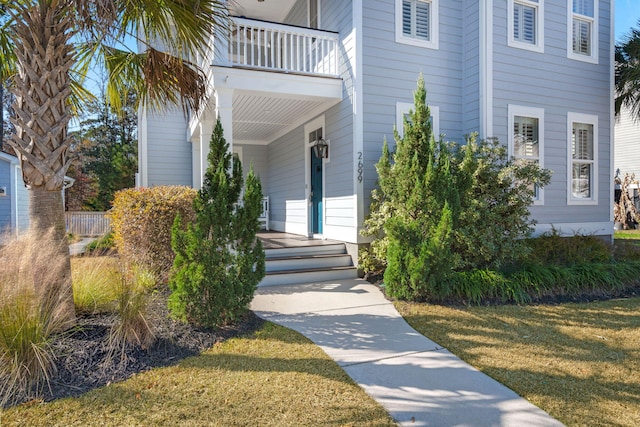 entrance to property with a balcony and a yard